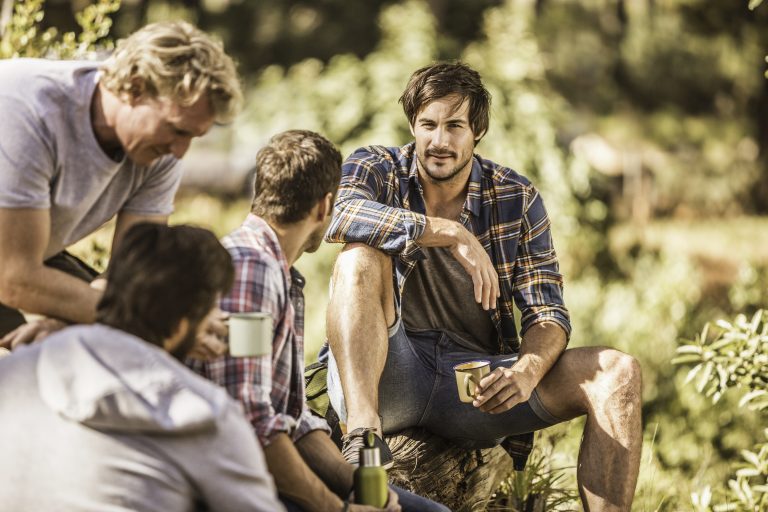Four male hikers sitting in forest, Deer Park, Cape Town, South Africa